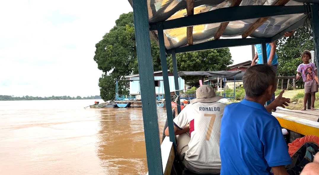 Bootsfähre über den Mekong nach Don Det, Blick von Bord auf das braune Flusswasser und das Ufer