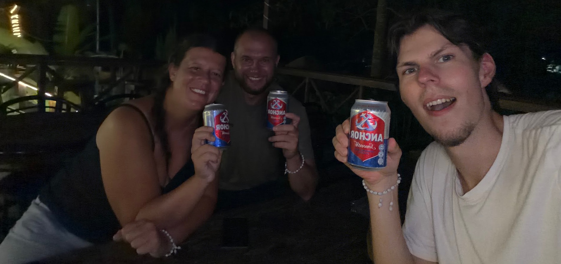 Kevin stößt abends mit Katie und Jamie mit Anchor-Bierdosen an
