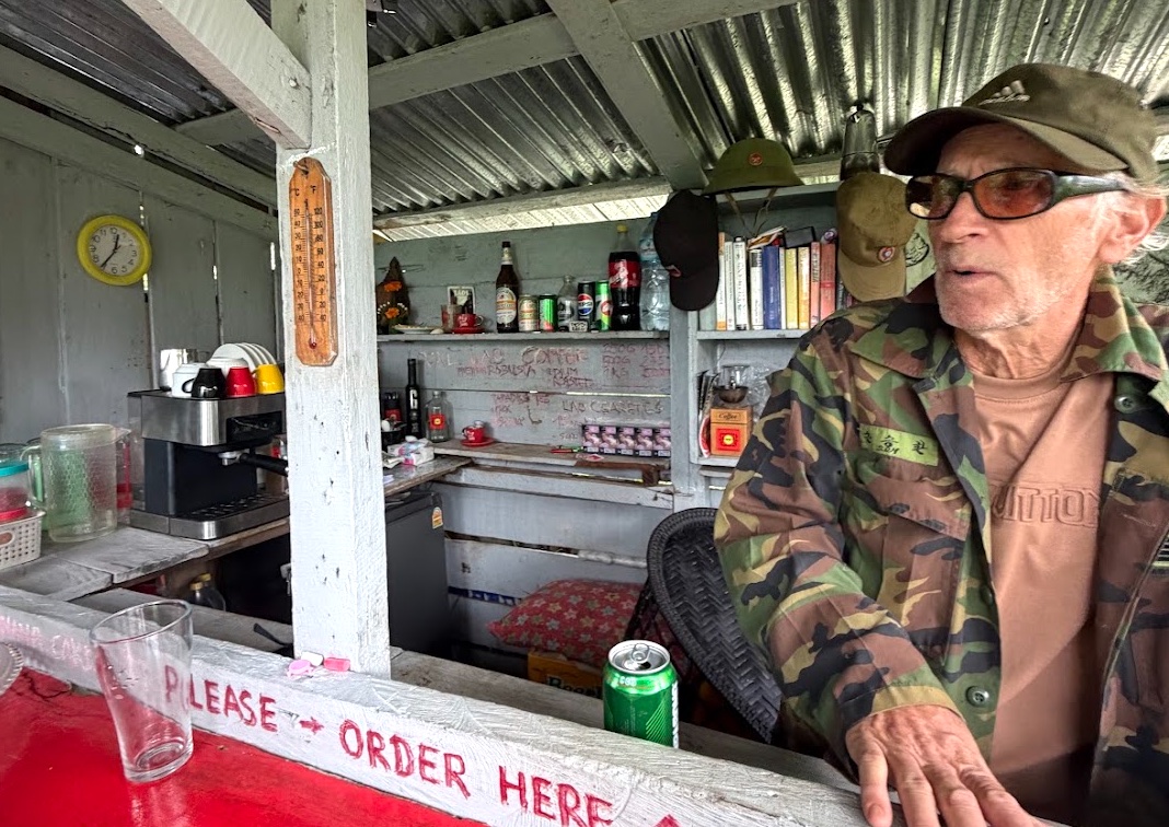 Der deutsche Besitzer vom Bolaven Paradise hinter seiner Theke im Bolaven-Plateau