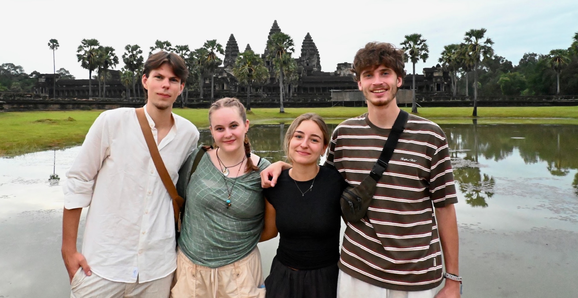 Kevin, Hannah, Laura und Otis vor Angkor Wat, im Hintergrund die Tempeltürme spiegeln sich im Wasser