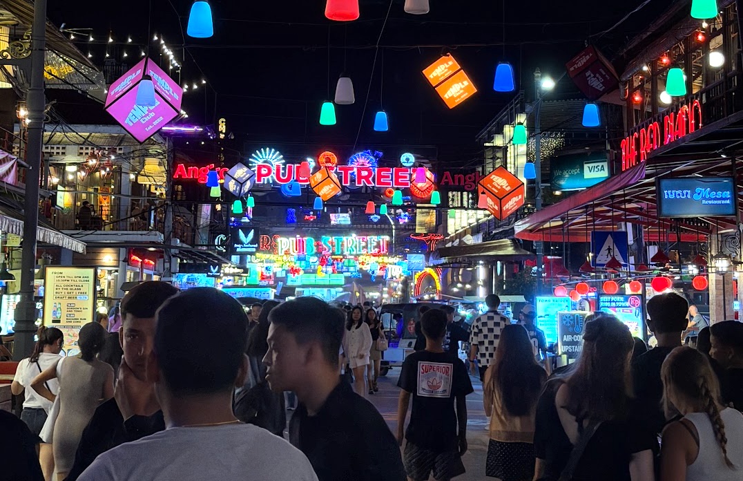 Die Pub Street in Siem Reap bei Nacht, voller bunter Neonlichter und Menschen