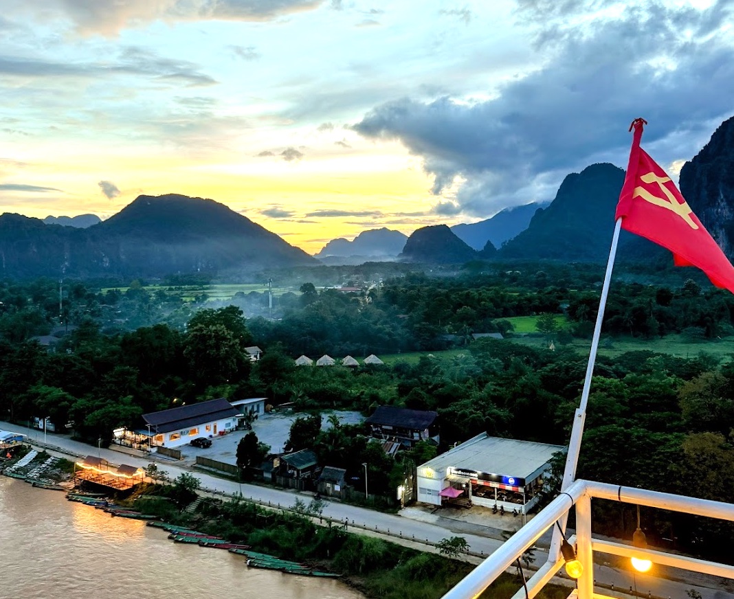 Sonnenuntergang über dem Fluss und den Karstbergen von Vang Vieng, Blick von der Elevate 9 Bar im Elephant Crossing Hotel