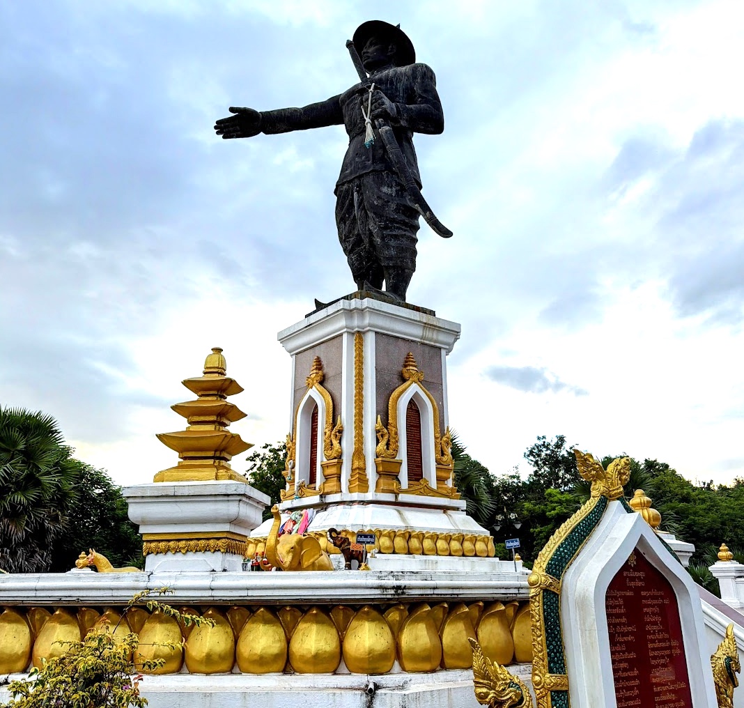 Die goldverzierte Chao-Anouvong-Statue in Vientiane, der König mit ausgestreckter Hand auf seinem Sockel